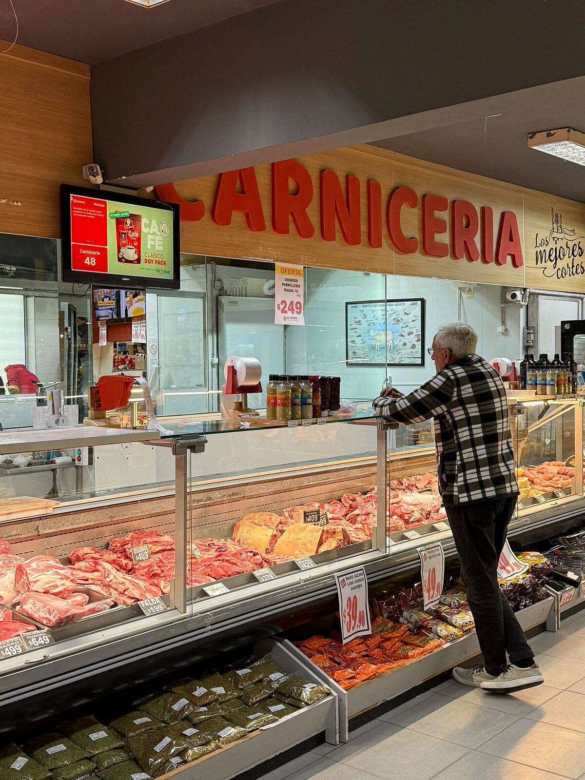 Pantalla DobleD en la carnicería de Supermercados El Paseo llamando el turno 48 junto a una publicidad de café y noticias