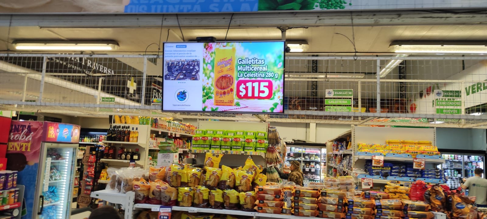 Pantalla de contenidos DobleD sobre los pasillos del Super Paraíso con una oferta, noticias y el logo del supermercado