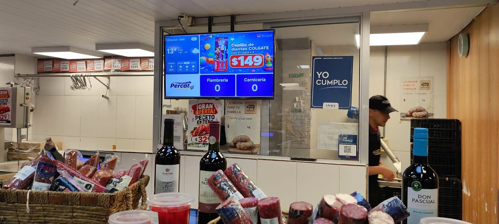 Pantalla DobleD sobre la carnicería del Supermercado Percat con los turnos de fiambrería y carnicería y una oferta