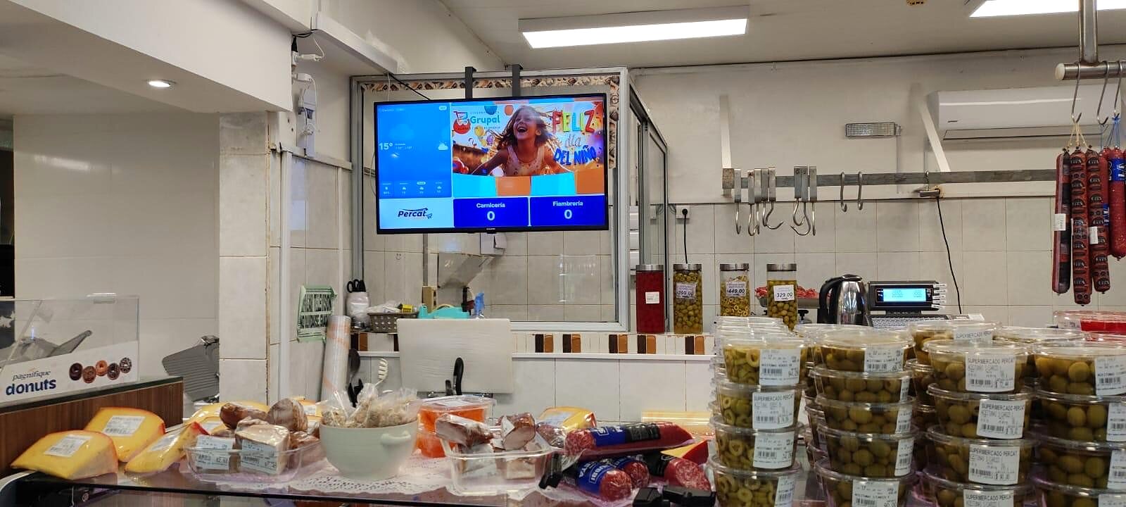 Pantalla DobleD en la fiambrería del Supermercado Percat con una campaña del Día del Niño y los turnos de carnicería y fiambrería